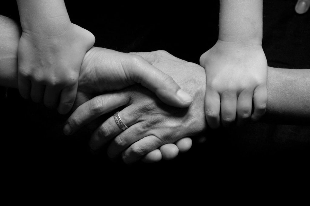 Child Holding Parents Hands Together