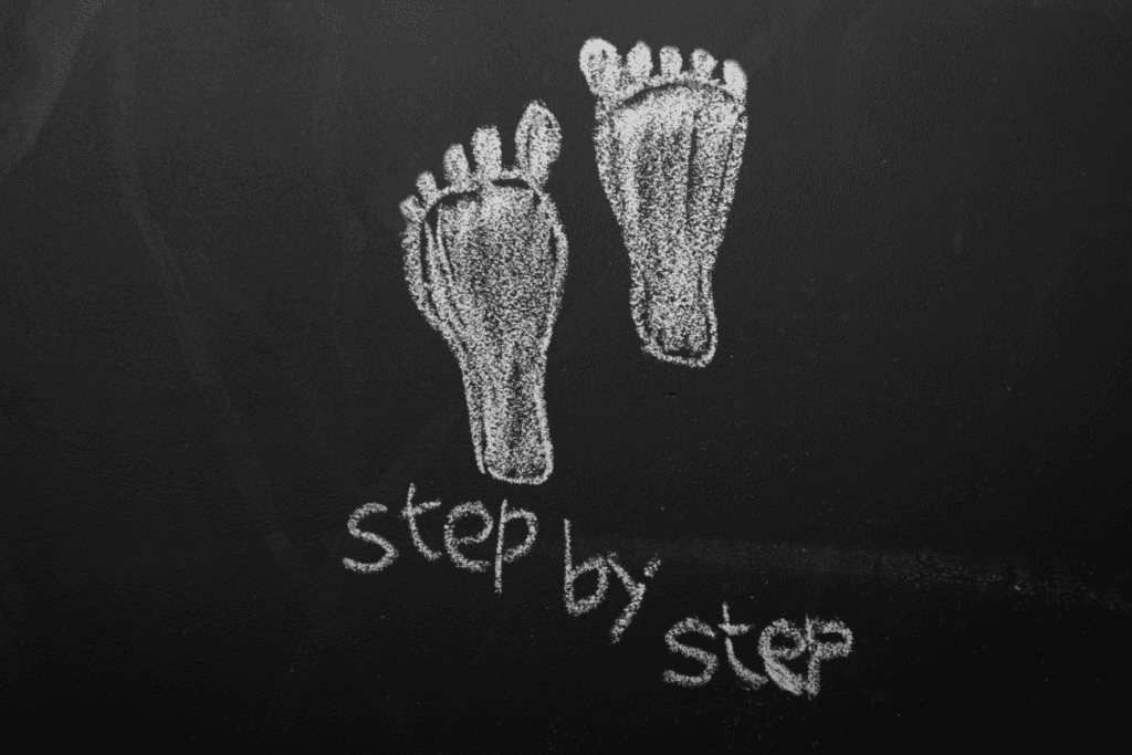 chalkboard with feet and the words step by step drawn on it.